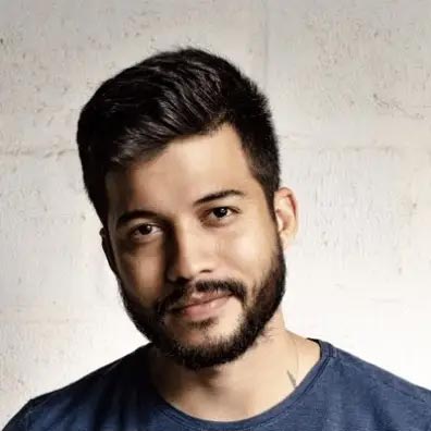 young man wearing shades and a hat with a beard, tattos and ear piercings